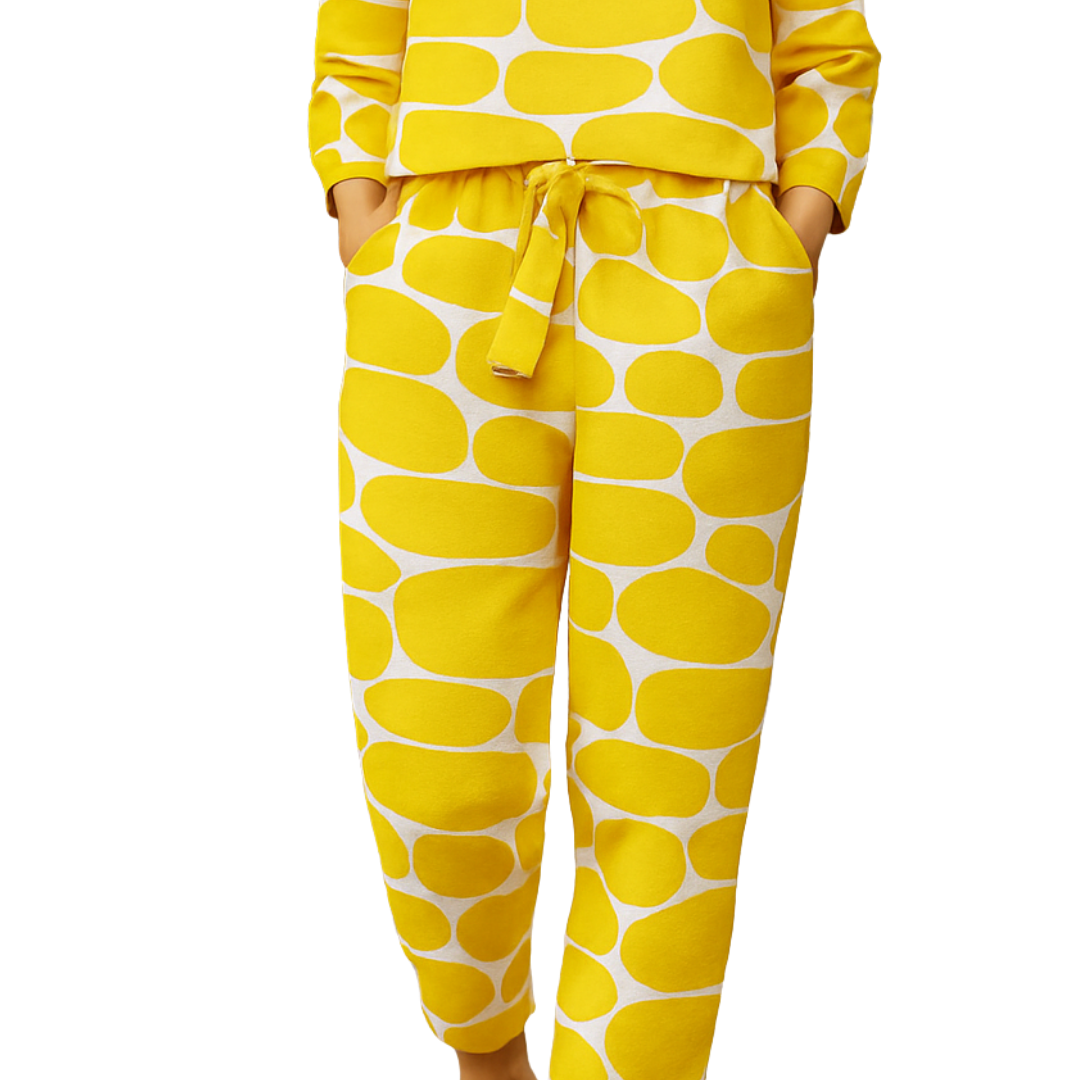 Woman wearing yellow and white patterned Lemon Pop Set with long sleeves and tied waist pants, paired with brown sandals.
