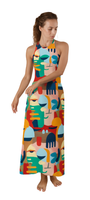 Woman wearing a Colour Rush dress featuring bold abstract faces and vibrant high-contrast hues in a halter-neck maxi style.