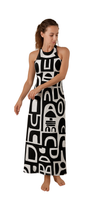 Woman wearing a black and white abstract halter-neck dress with bold shapes, Decode Me Maxi on a white background.