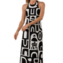 Woman wearing a black and white abstract halter-neck dress with bold shapes, Decode Me Maxi on a white background.