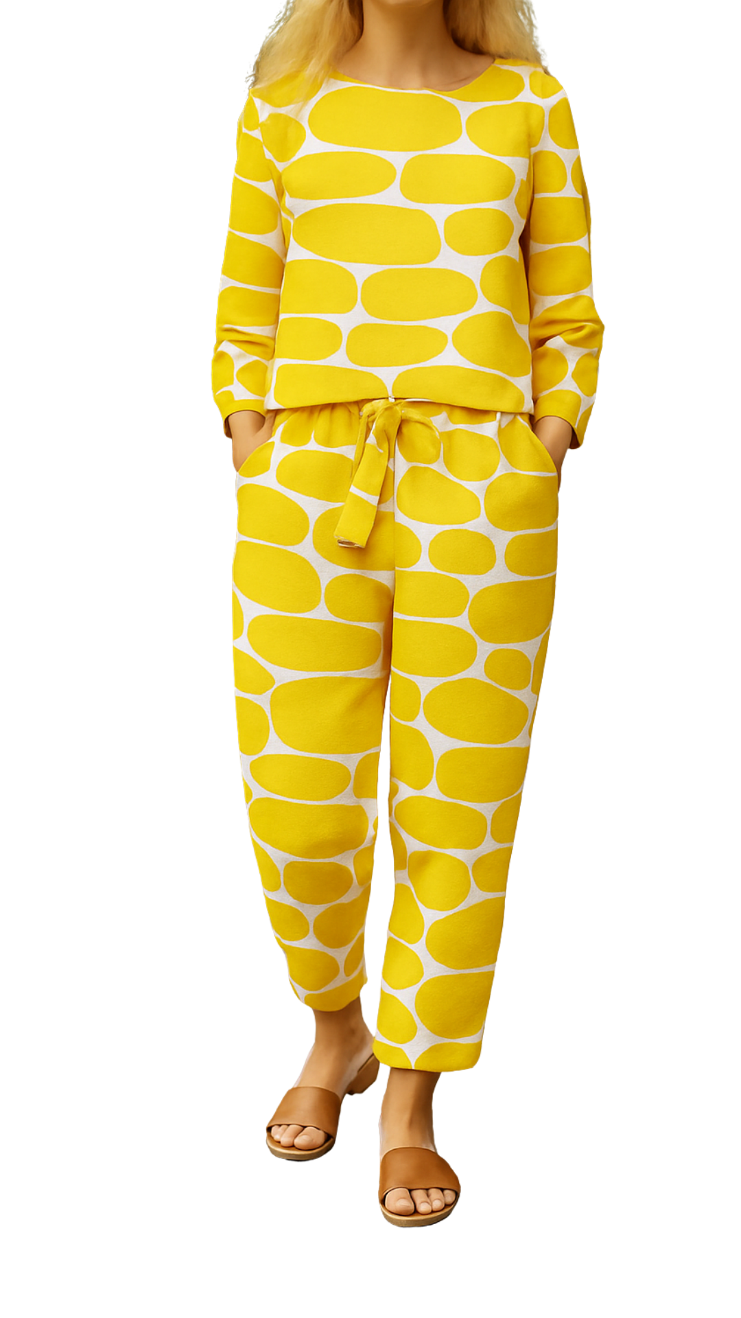 Woman wearing yellow and white patterned Lemon Pop Set with long sleeves and tied waist pants, paired with brown sandals.