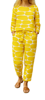 Woman wearing yellow and white patterned Lemon Pop Set with long sleeves and tied waist pants, paired with brown sandals.
