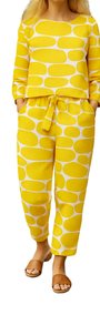 Woman wearing yellow and white patterned Lemon Pop Set with long sleeves and tied waist pants, paired with brown sandals.