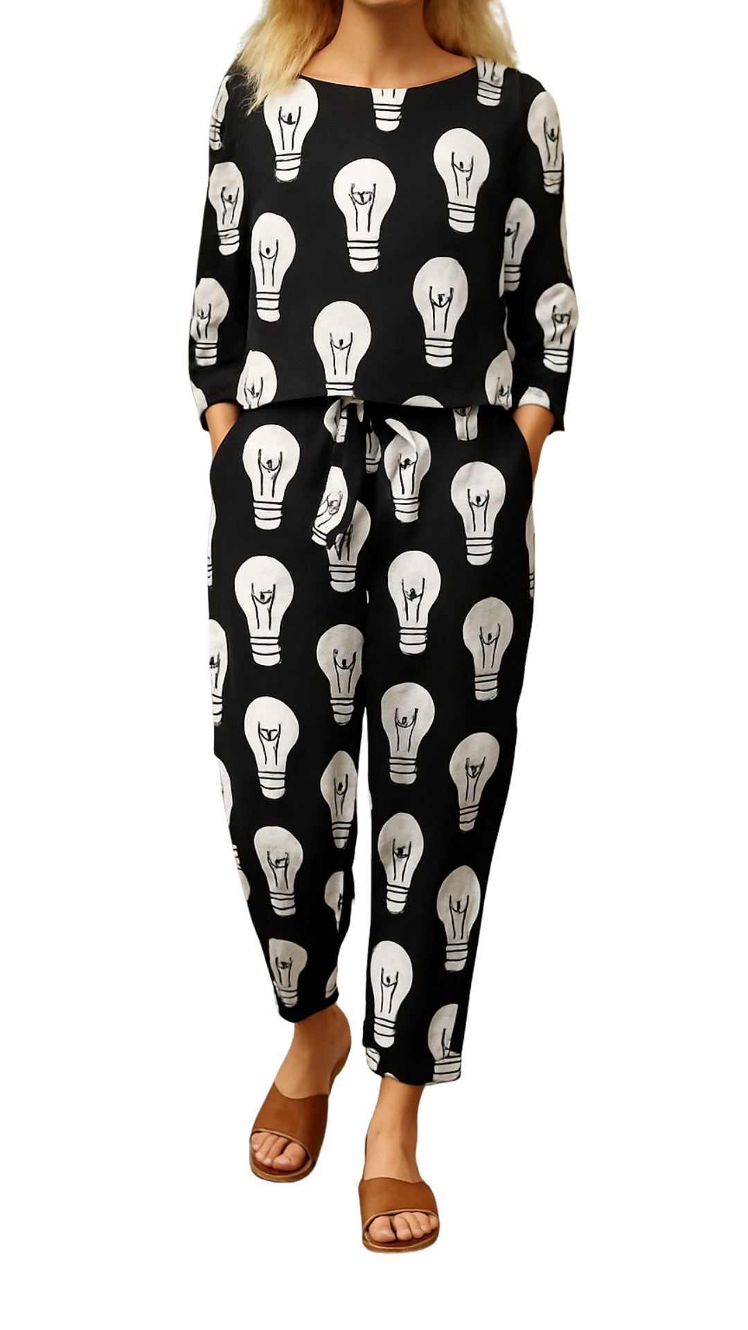 Woman wearing Lit Up Co-ord Set with black fabric covered in white hand-drawn light bulb motifs, paired with brown sandals.