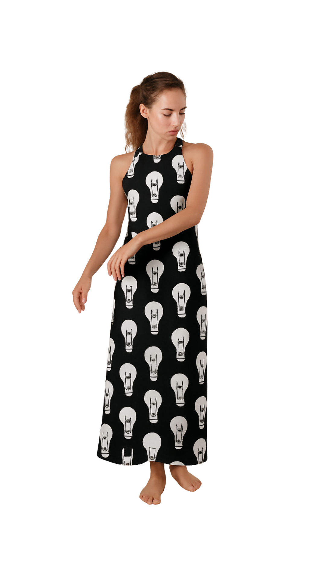 Woman wearing a black halter maxi dress with white lightbulb print, titled Maxi-Mum Voltage, standing barefoot.